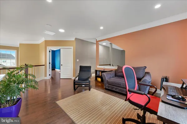 a living room with furniture a piano and wooden floor