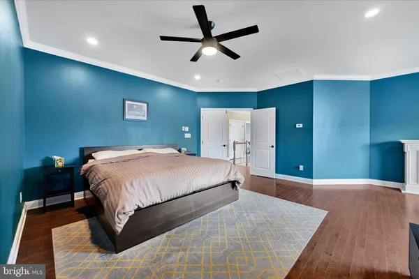 a spacious bedroom with a bed and a ceiling fan