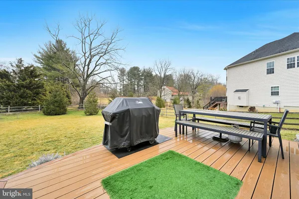 a view of a roof deck with table and chairs with wooden floor and fence