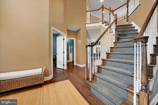 a view of staircase with wooden floor and white walls
