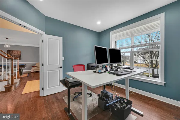 a view of a workspace with furniture and wooden floor
