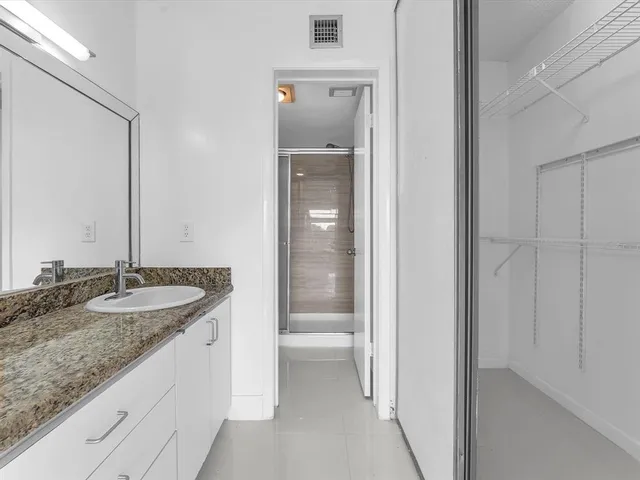 a bathroom with a granite countertop sink and a mirror