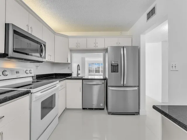 a kitchen with a refrigerator stove and microwave