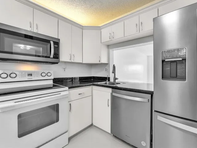 a kitchen with cabinets stainless steel appliances and sink
