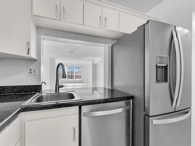 a kitchen with stainless steel appliances granite countertop a refrigerator and a sink