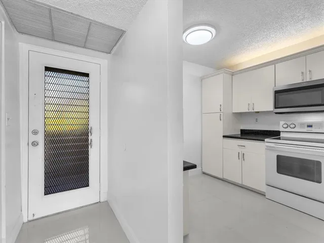 a kitchen with stainless steel appliances white cabinets and a refrigerator