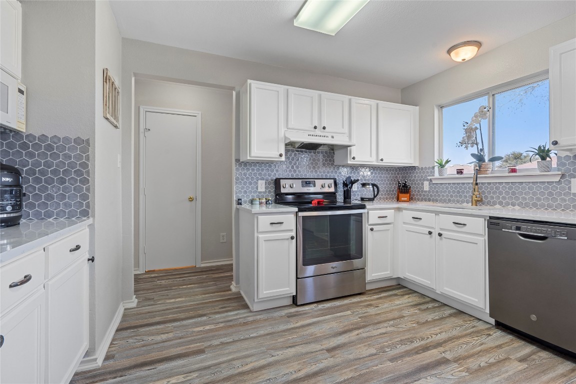 202 Rinehardt Street Hutto, TX 78634 - Photo 14 of 31 a kitchen with white cabinets stainless steel appliances and sink