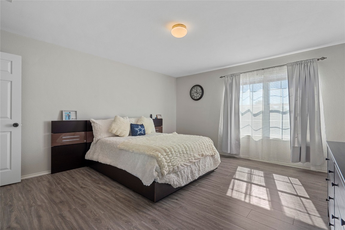 202 Rinehardt Street Hutto, TX 78634 - Photo 19 of 31 a bedroom with a bed and wooden floor