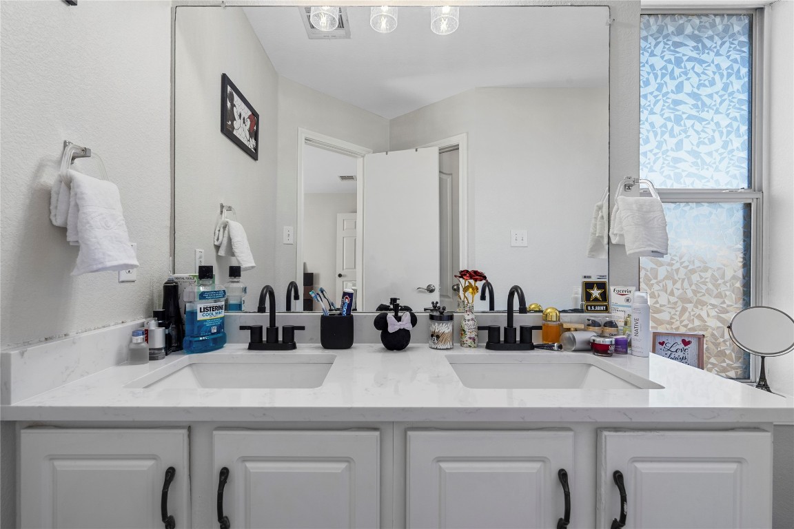 202 Rinehardt Street Hutto, TX 78634 - Photo 22 of 31 a bathroom with a sink and a mirror