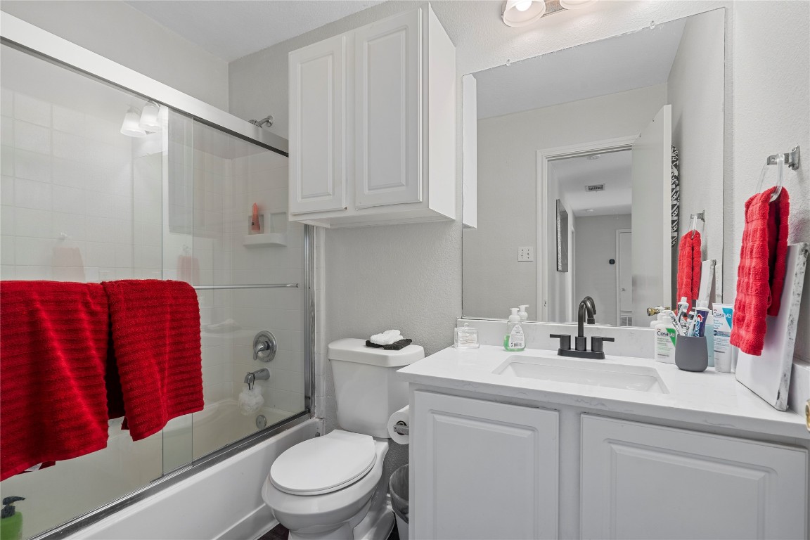 202 Rinehardt Street Hutto, TX 78634 - Photo 24 of 31 a bathroom with a toilet sink vanity and mirror