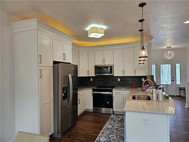 a kitchen with a refrigerator a stove a sink and a cabinets