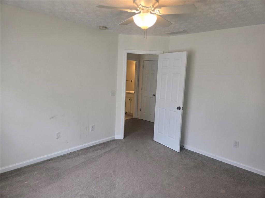 22 Windcrest Keep Covington, GA 30016 - Photo 26 of 32 an empty room with a chandelier fan and a bathroom