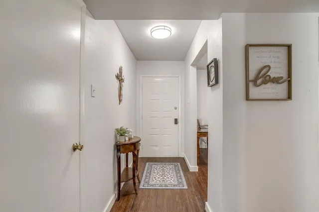 a view of hallway with walk in closet and wooden floor