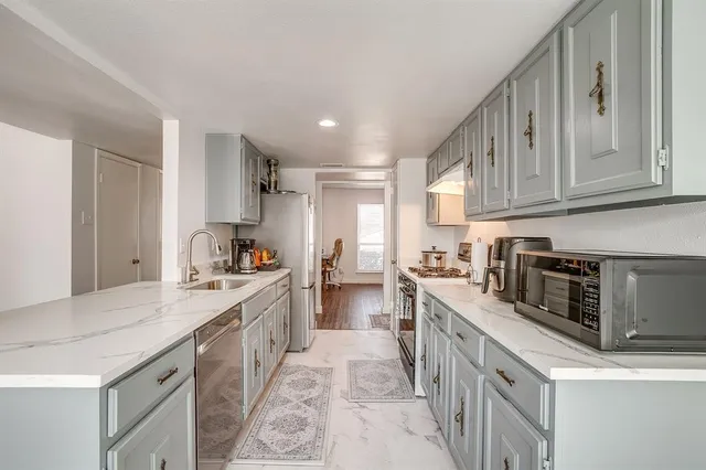 a large kitchen with stainless steel appliances granite countertop a stove and a sink