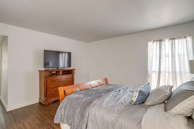 a bedroom with a bed and wooden floor