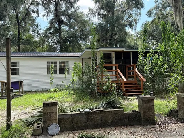 a view of a house with backyard and sitting area