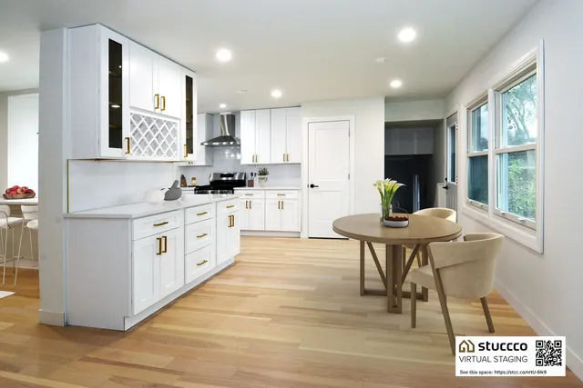 a kitchen with stainless steel appliances kitchen island granite countertop a table chairs sink and cabinets