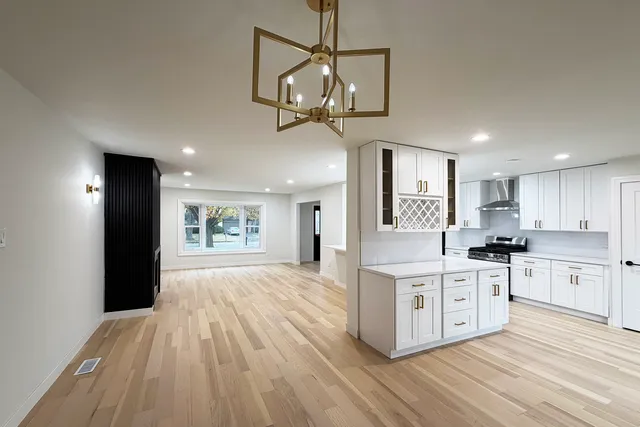 a kitchen with stainless steel appliances granite countertop a stove and cabinets with wooden floor