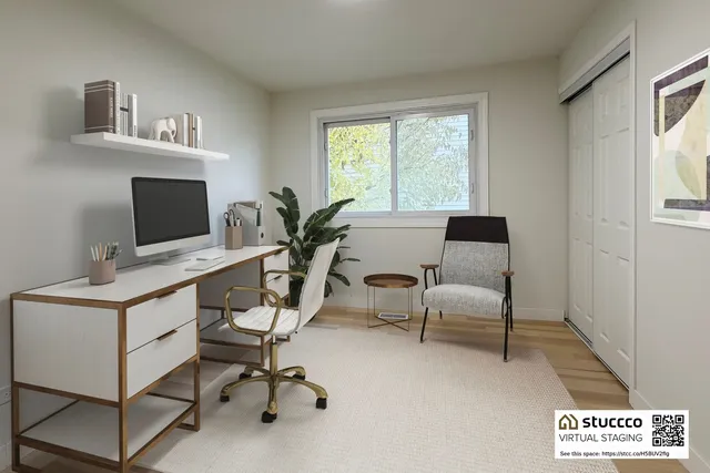 a view of a workspace with furniture and a window