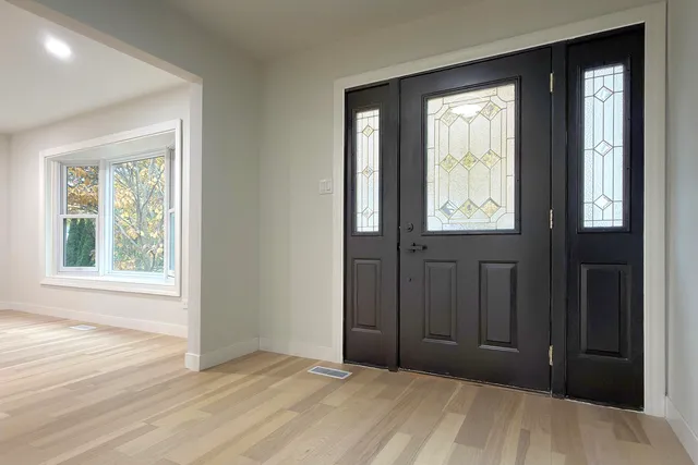 an empty room with window and closet area