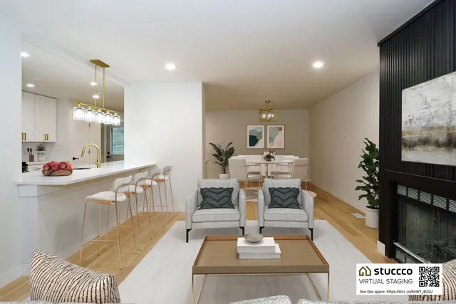 a living room with furniture a flat screen tv and kitchen view