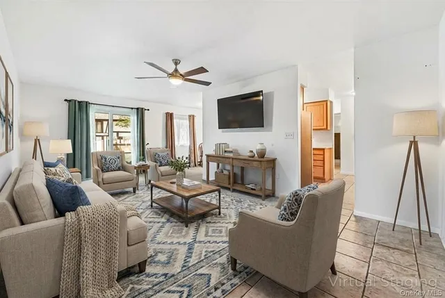 a living room with furniture a flat screen tv and a large window