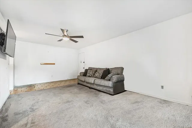 a living room with furniture and a ceiling fan
