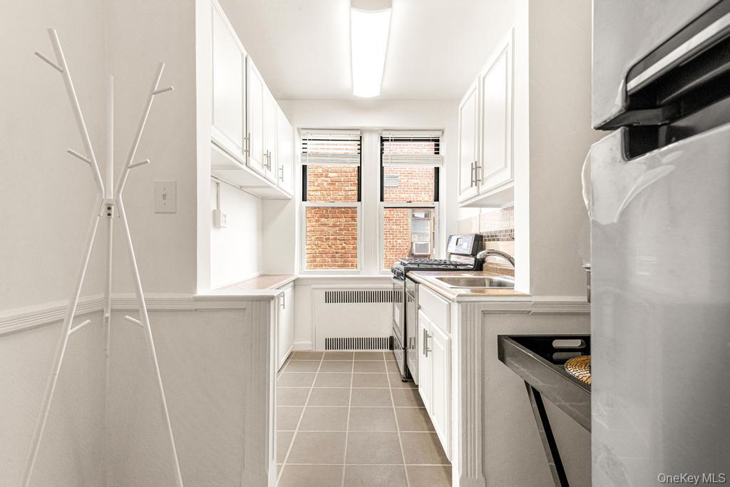 100-10 67th Road, Unit 6L Queens, NY 11375 - Photo 6 of 26 a kitchen with a sink a stove and a refrigerator