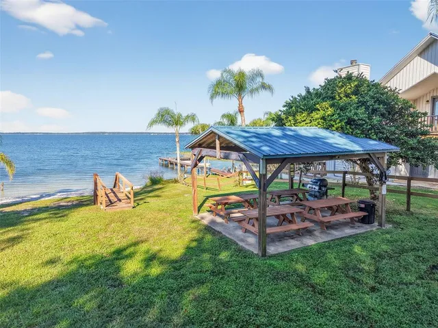 a view of a swimming pool with a table and chairs under an umbrella