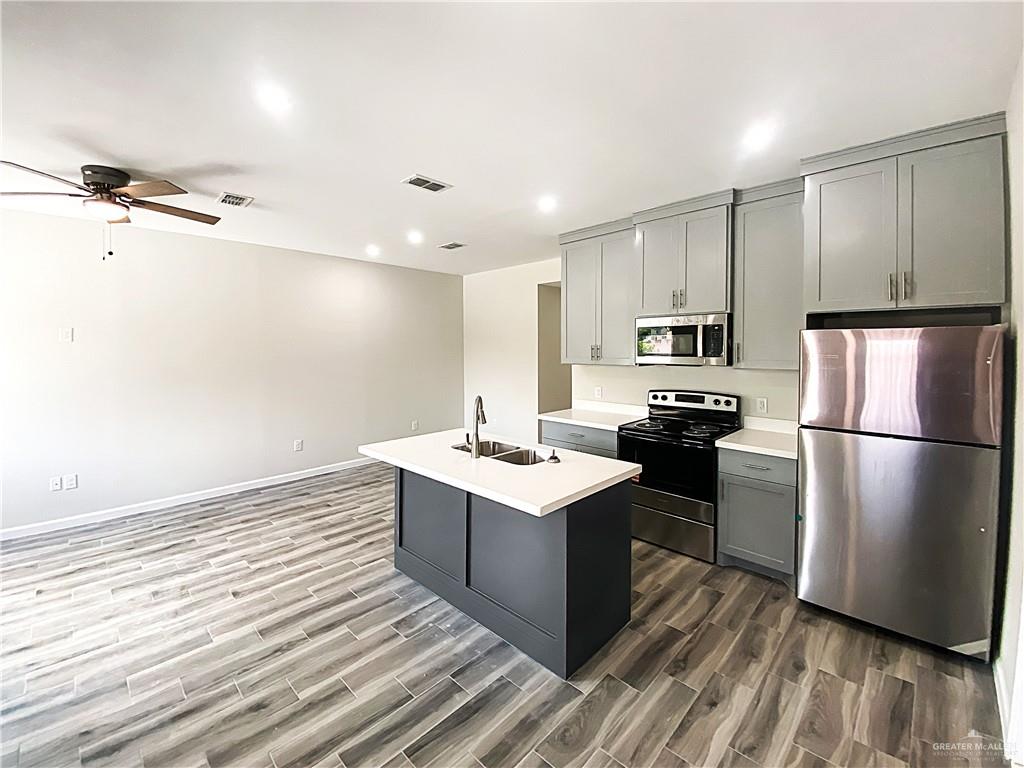 5048 McKenzie Road Brownsville, TX 78521 - Photo 2 of 11 a kitchen with kitchen island a sink stove and refrigerator