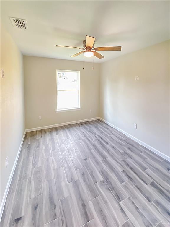5048 McKenzie Road Brownsville, TX 78521 - Photo 6 of 11 wooden floor in an empty room with a window