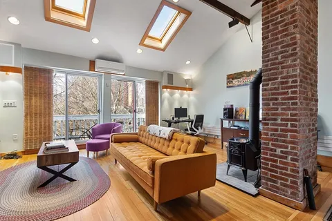 a living room with fireplace furniture and a large window