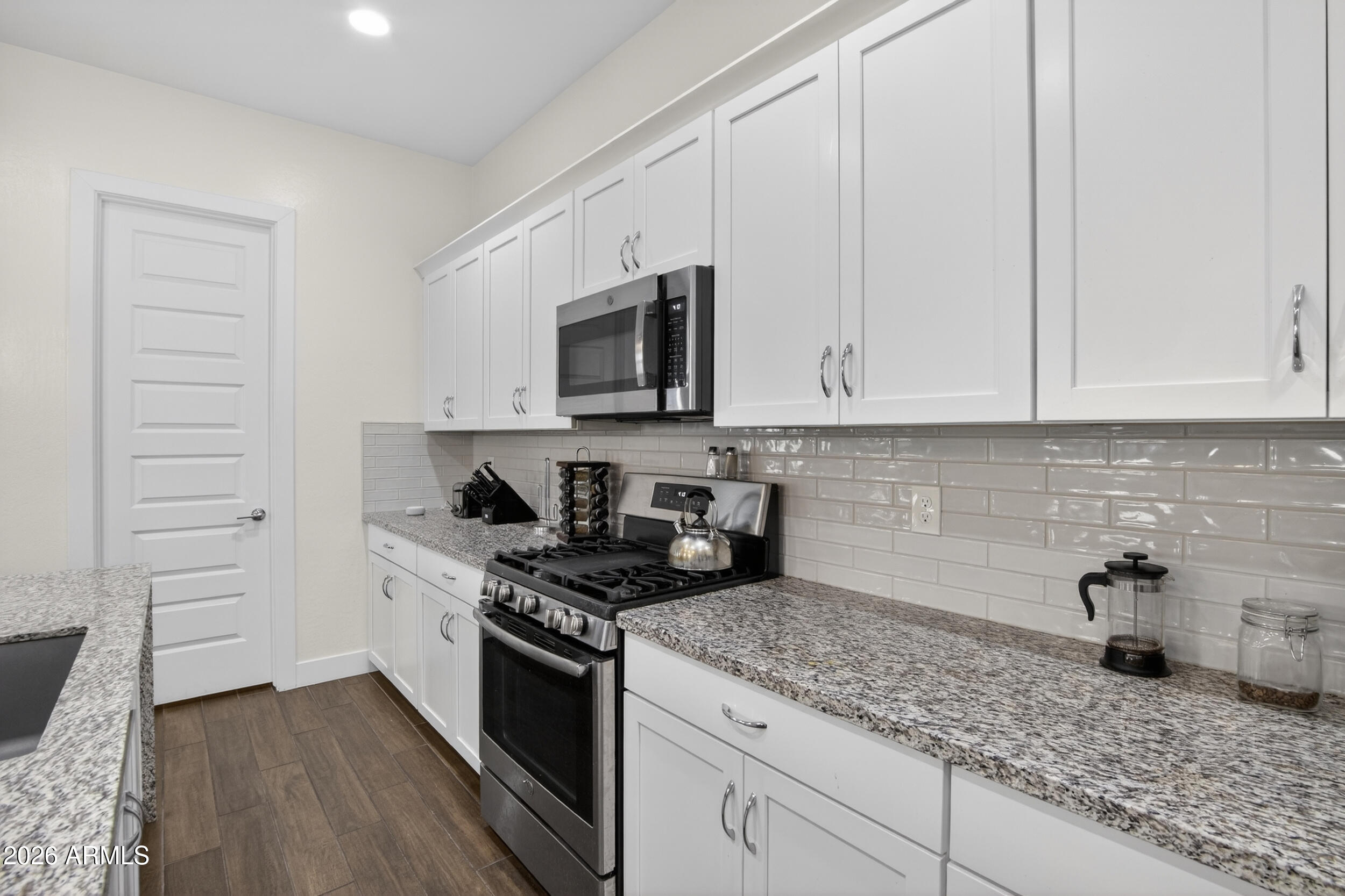 939 East Paseo Way Phoenix, AZ 85042 - Photo 20 of 78 a kitchen with granite countertop white cabinets and stainless steel appliances