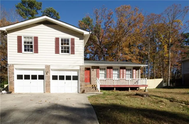 a view of house with yard and trees in the background