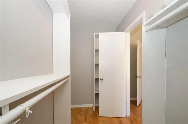 wooden floor fireplace and windows in an empty room