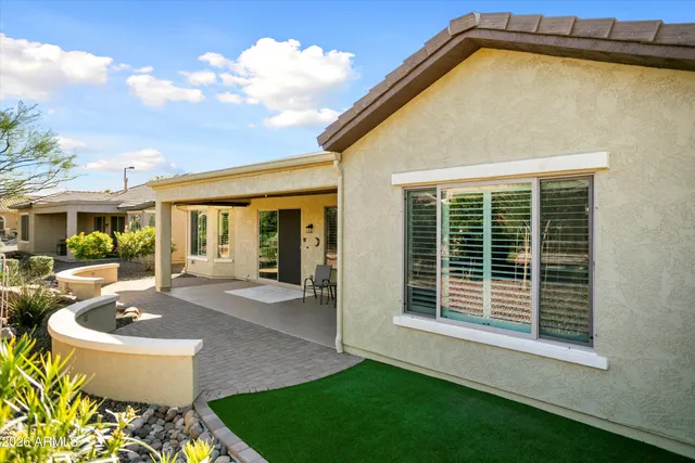 a view of a patio with a table and chairs under an umbrella