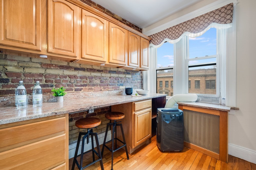 3 Crawford Street, Unit 9 Cambridge, MA 02139 - Photo 13 of 23 a kitchen with stainless steel appliances granite countertop a sink a stove and a wooden cabinets