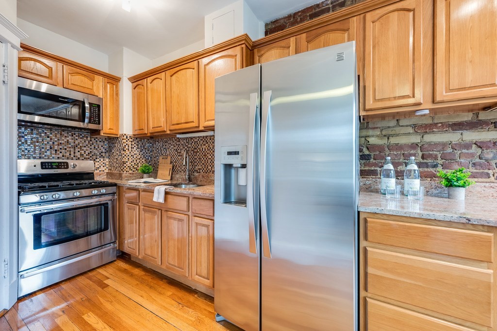 3 Crawford Street, Unit 9 Cambridge, MA 02139 - Photo 17 of 23 a kitchen with stainless steel appliances granite countertop a refrigerator and a stove top oven