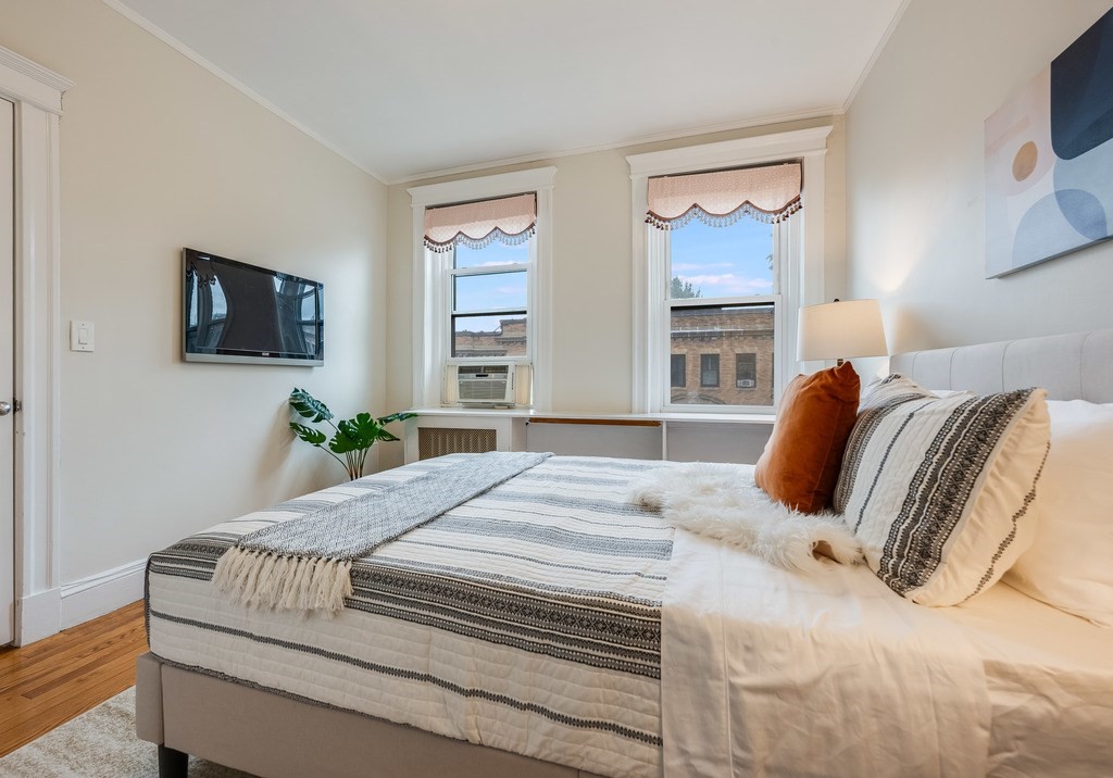 3 Crawford Street, Unit 9 Cambridge, MA 02139 - Photo 22 of 23 a bedroom with a bed and flat screen tv