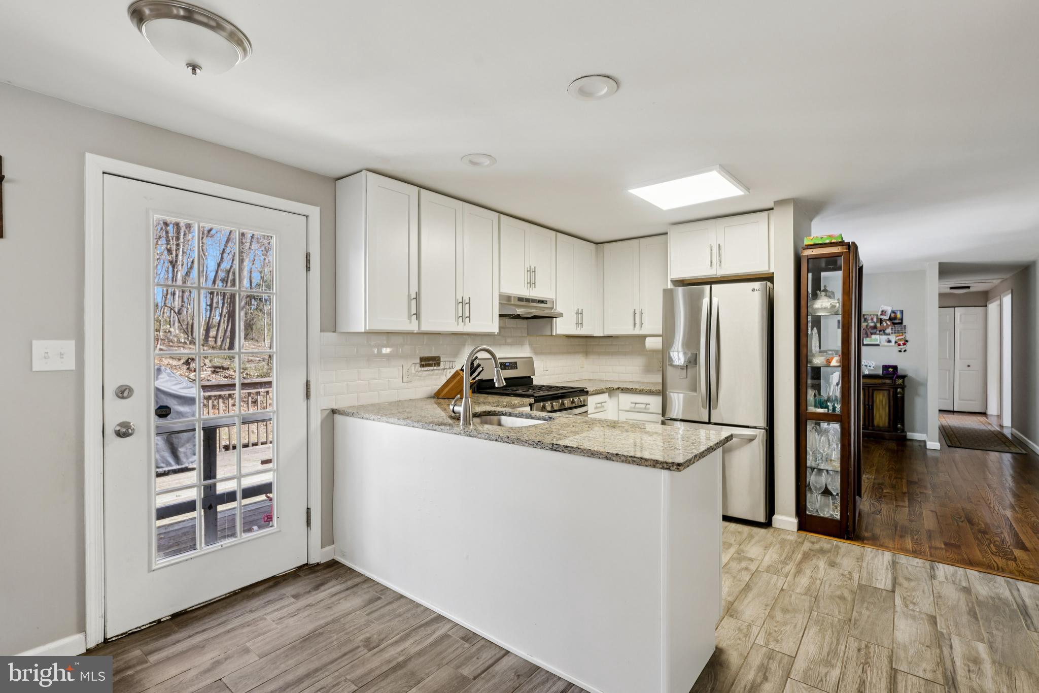 78 Rising Sun Tavern Road Millstone Township, NJ 08510 - Photo 18 of 55 a kitchen with stainless steel appliances granite countertop a refrigerator a stove and a wooden floors
