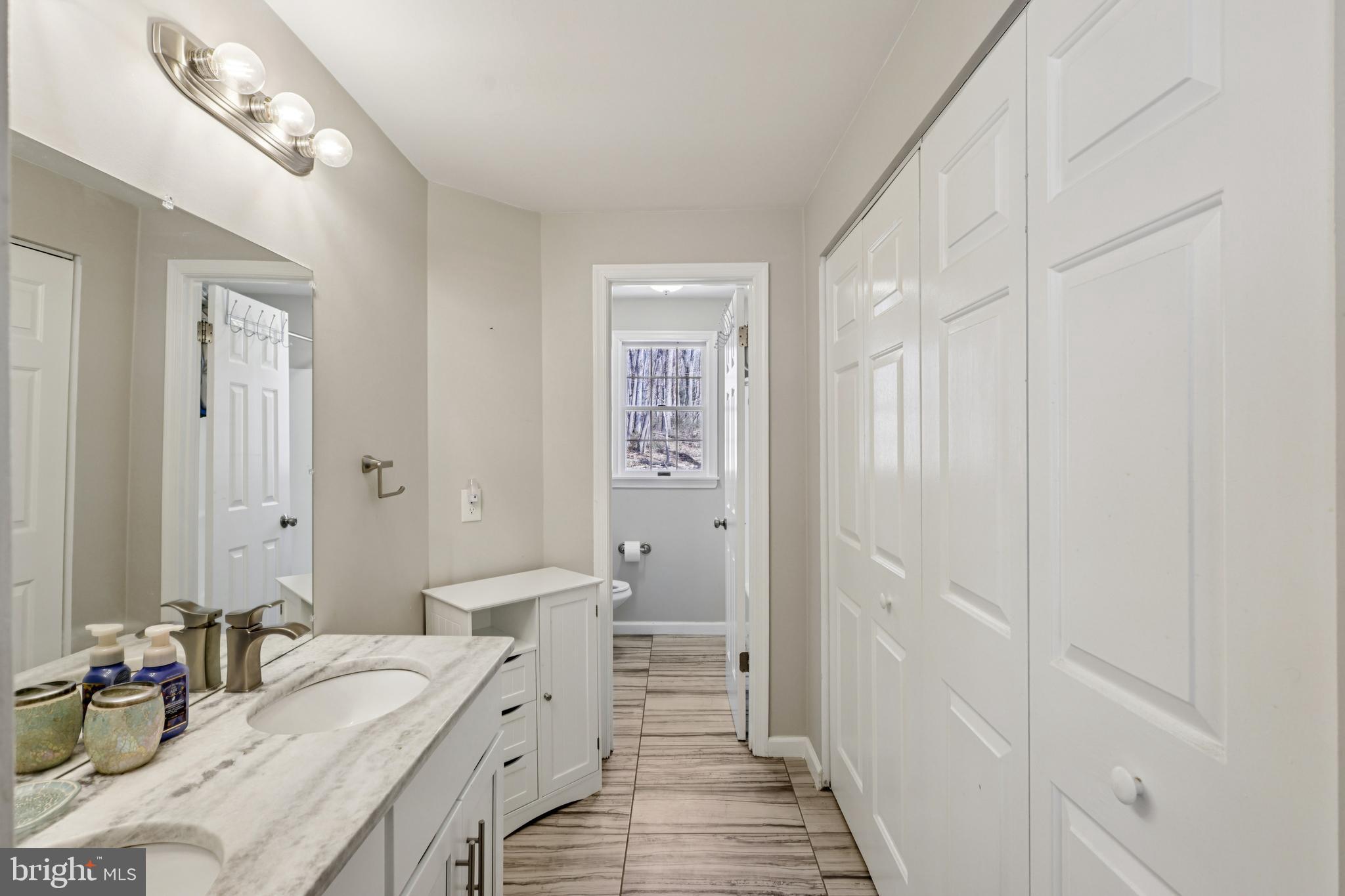 78 Rising Sun Tavern Road Millstone Township, NJ 08510 - Photo 35 of 55 a bathroom with a double vanity sink and a mirror
