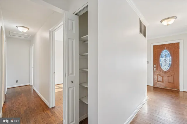an empty room with wooden floor and window