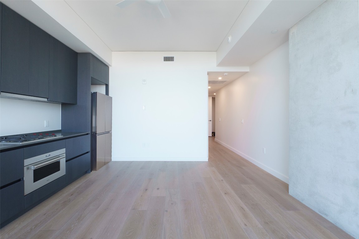 610 Davis Street, Unit 4708 Austin, TX 78701 - Photo 21 of 29 a view of a kitchen with wooden floor and a refrigerator