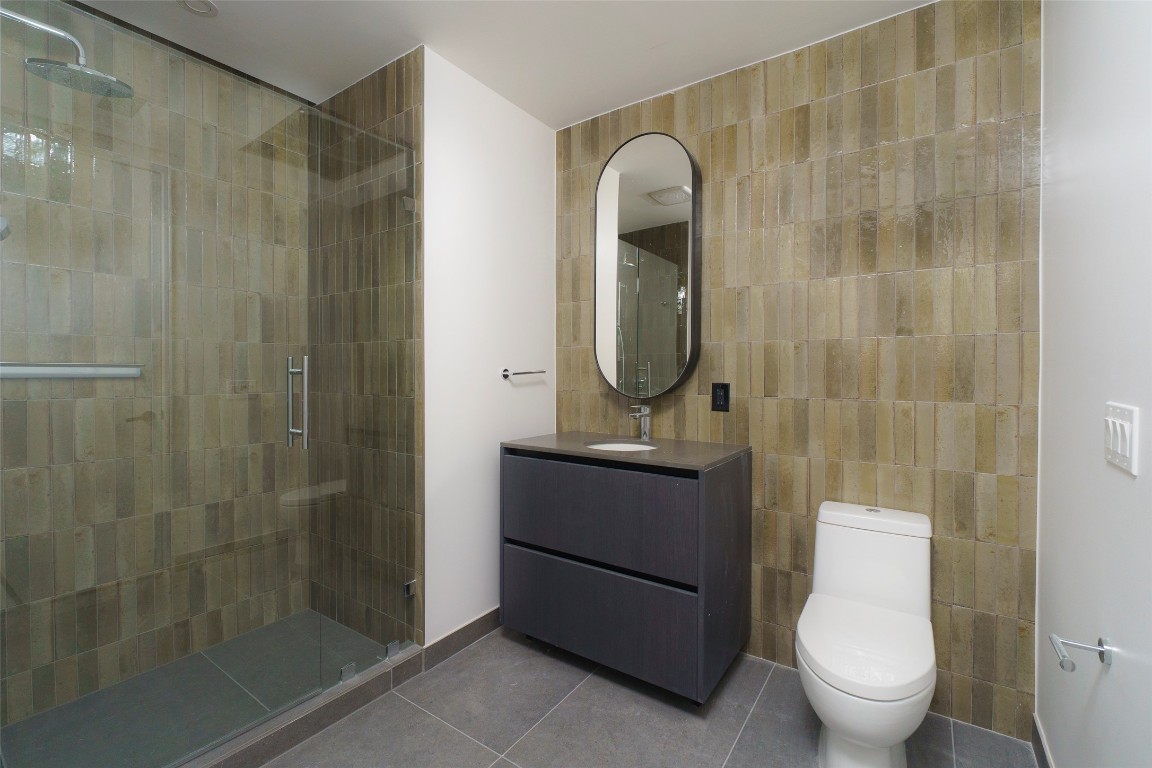 610 Davis Street, Unit 4708 Austin, TX 78701 - Photo 23 of 29 a bathroom with a toilet a sink and shower