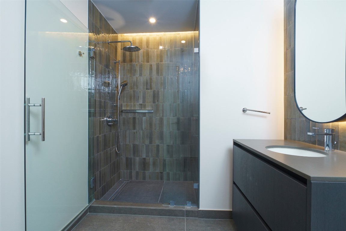 610 Davis Street, Unit 4708 Austin, TX 78701 - Photo 25 of 29 a bathroom with a shower a sink and mirror