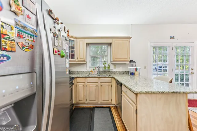 a kitchen with stainless steel appliances granite countertop a refrigerator and a sink