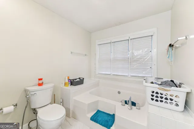a white toilet sitting next to a bath tub