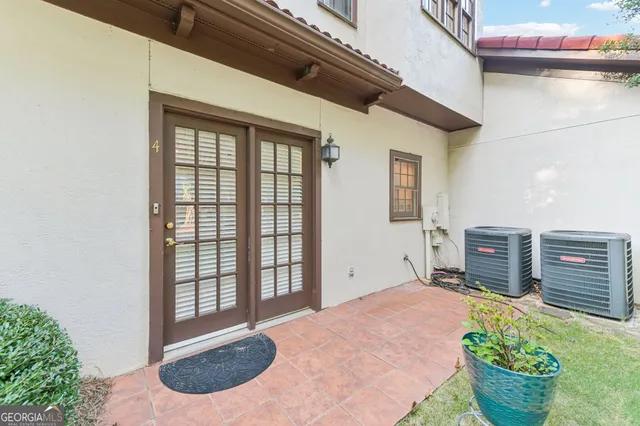 a view of a porch with a potted plant and floor to ceiling window