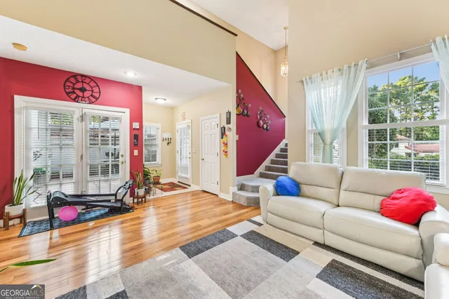 a living room with furniture kitchen view and a large window
