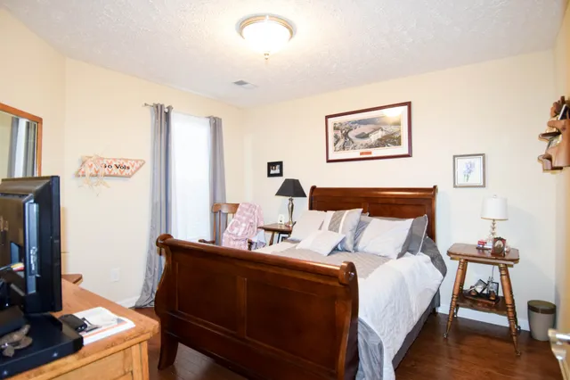 a bedroom with a bed and wooden floor